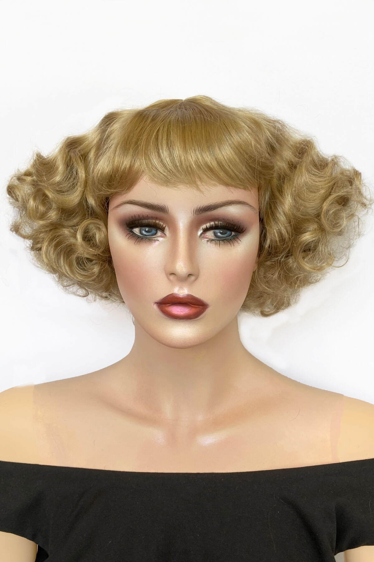 Mannequin head with blonde wig and makeup on a white background. A short blonde vintage style wig with waves: Joy