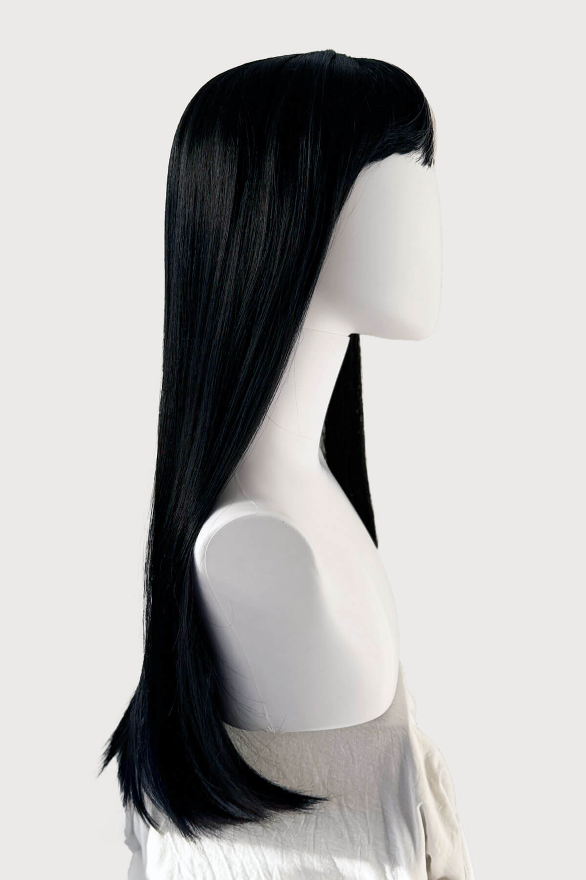 Black wig on a mannequin head against a white background. Long, black, straight wig with platinum fringe streak and retro, straight fringe: Imogen