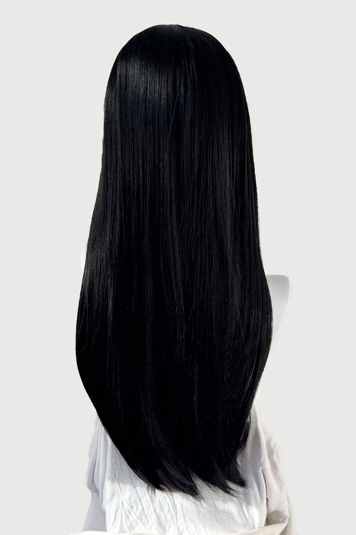 Mannequin head with long black hair on a white background. Long, black, straight wig with platinum fringe streak and retro, straight fringe: Imogen