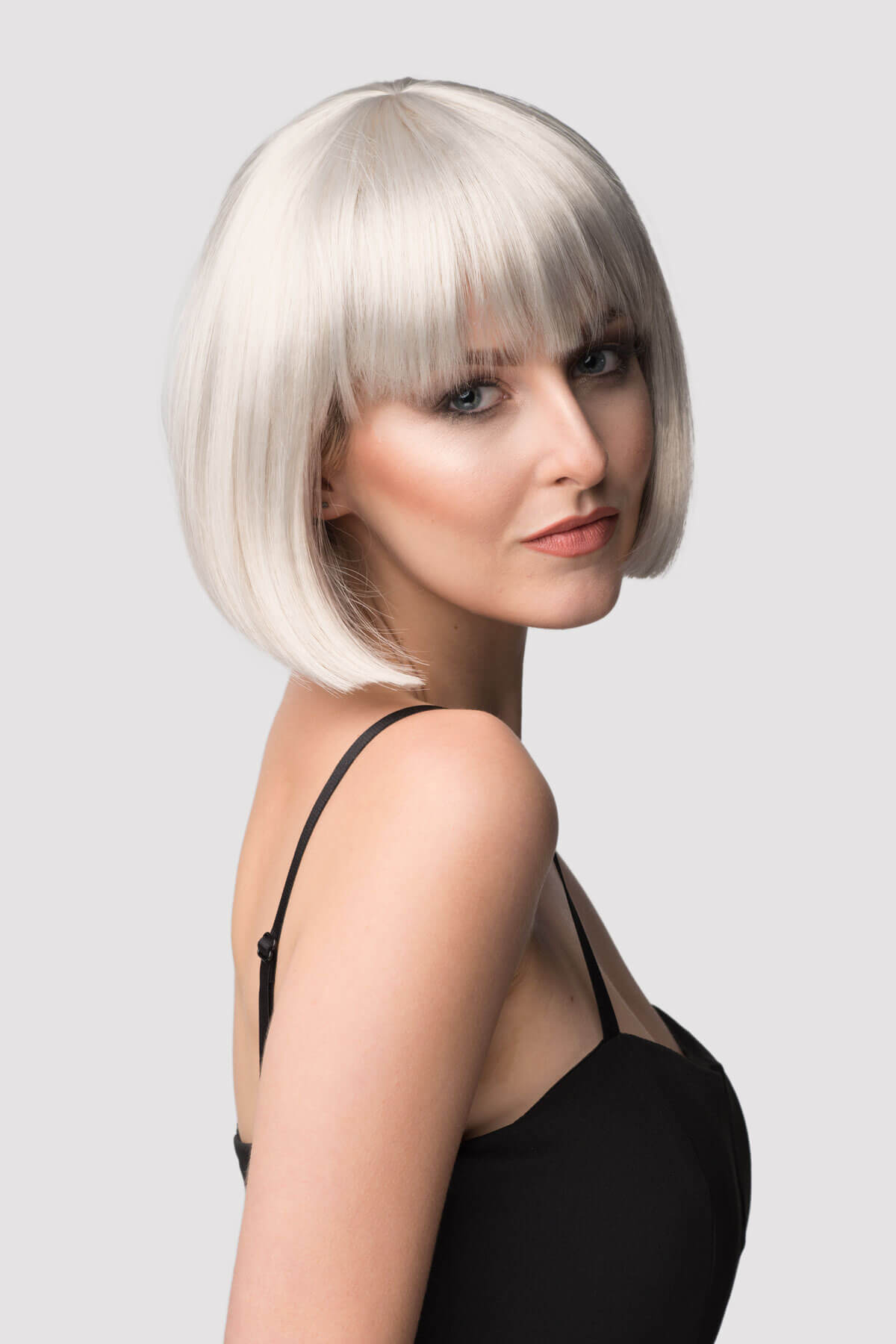 Woman with a stylish haircut against a plain background. Satin-grey/silver bob wig, short and chic: Celeste