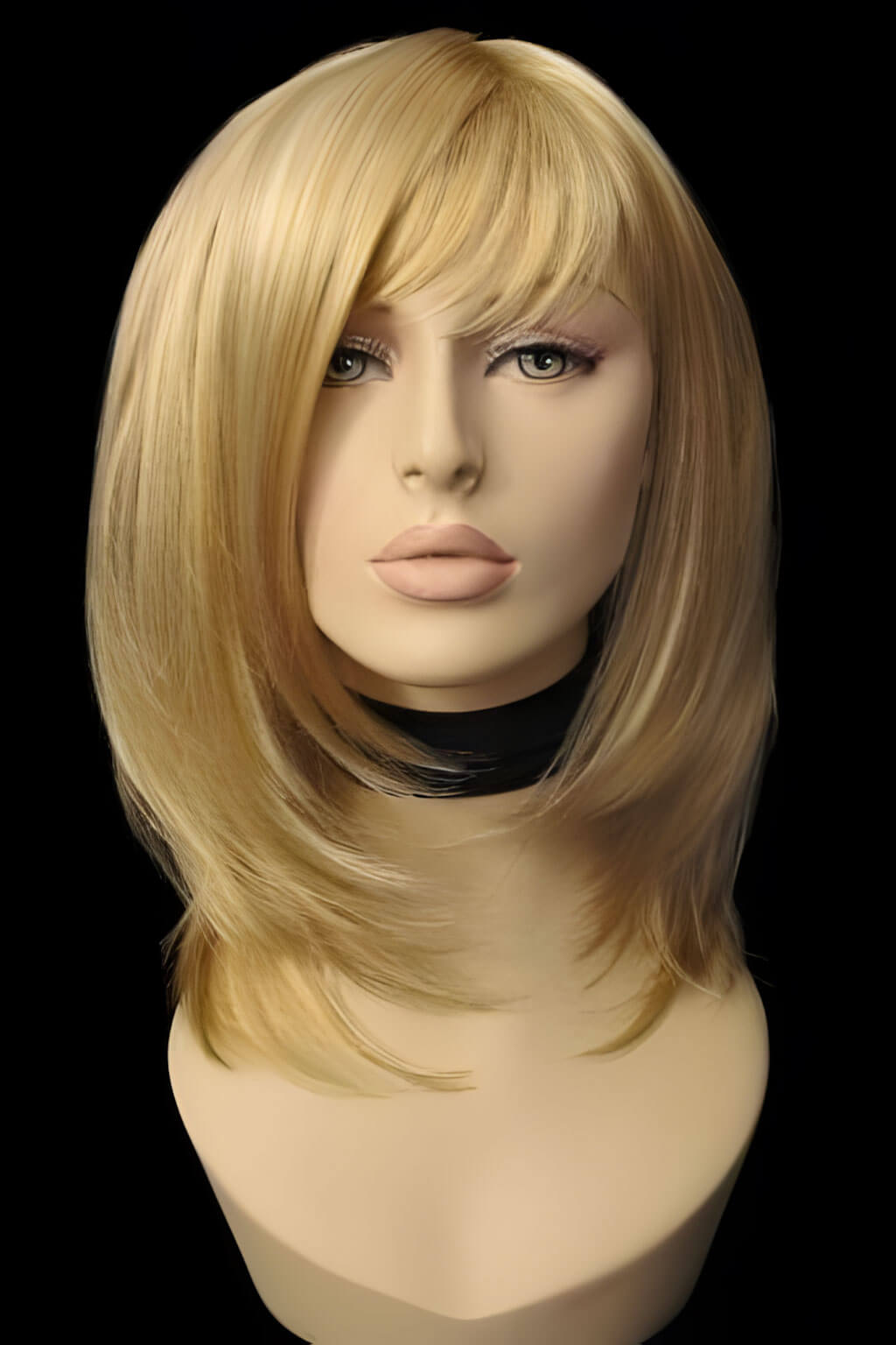 Blonde wig on a mannequin head against a black background