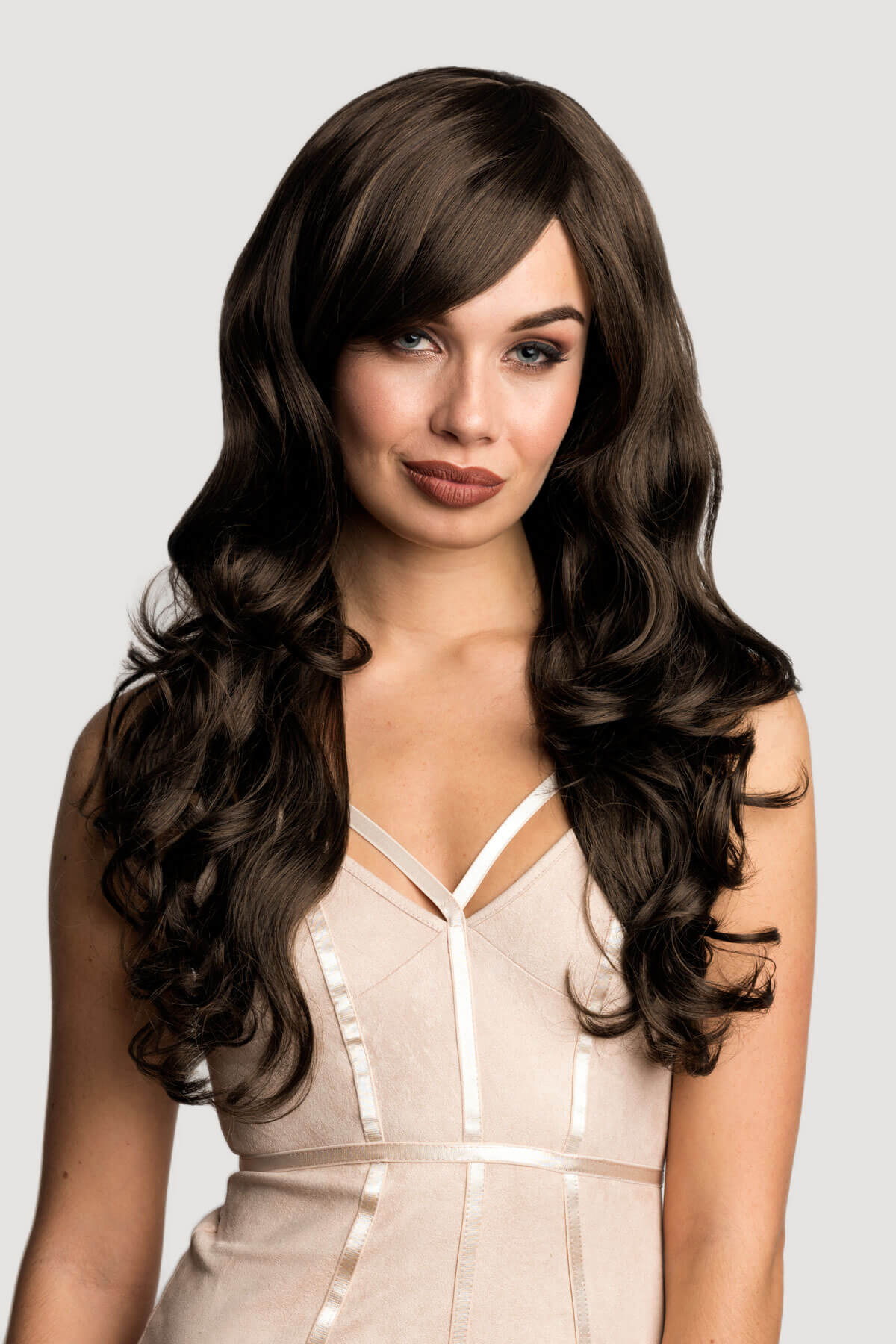 Woman with long, wavy brown hair wearing a beige dress on a light gray background.Long brown wig with gentle waves: Bella reddish brown 33