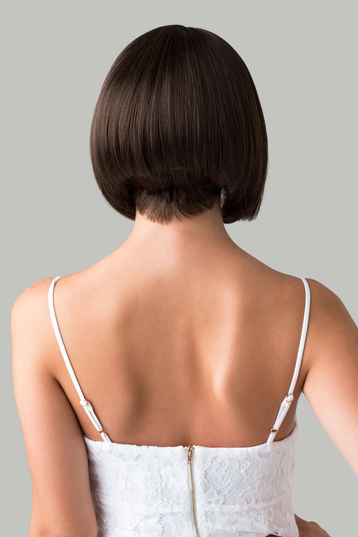 Person wearing a white dress with thin straps against a gray background. Brown inverted bob wig: Colettechestnut brown 8