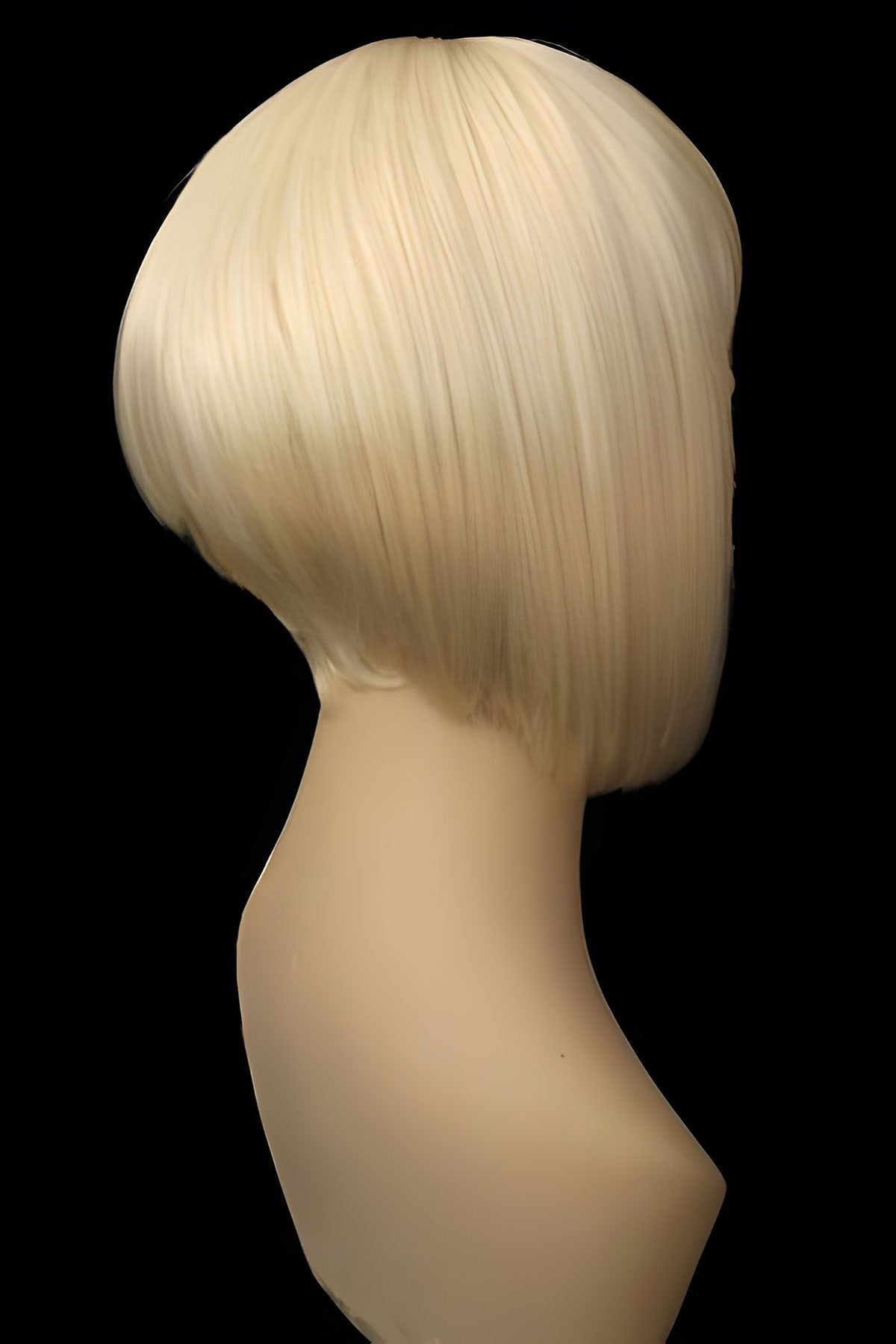 Blonde wig on a mannequin head against a black background. Blonde inverted bob wig: Rhiannon champagne blonde 613