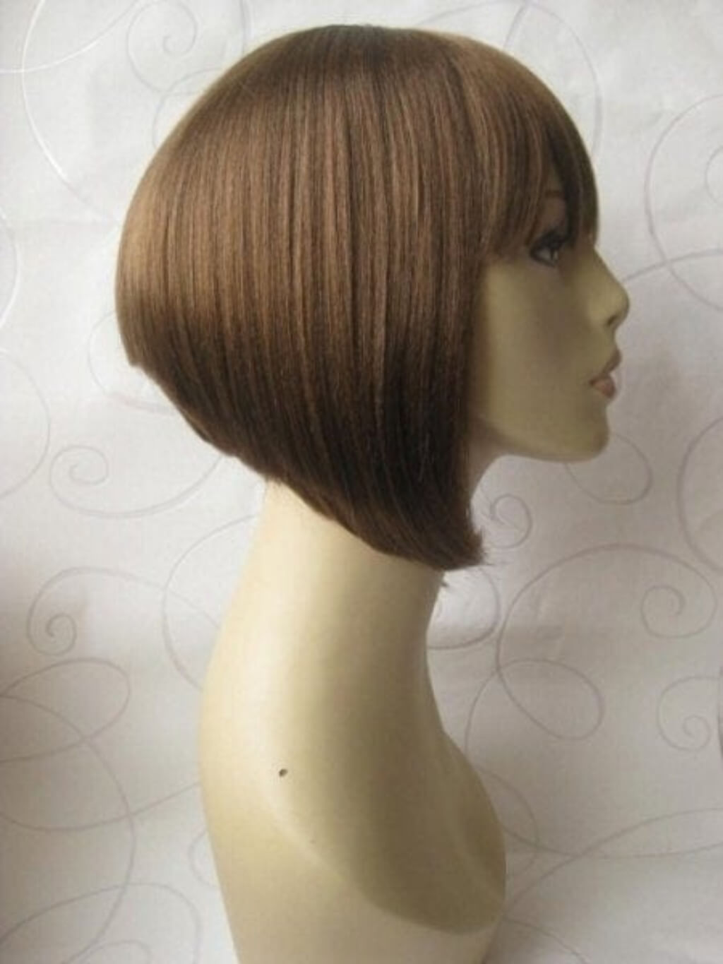 A straight, shoulder-length brown wig with side-swept bangs displayed on a beige mannequin head against a light patterned backdrop. Brown inverted bob wig, inverted/A-Line style: Colette  light brown 12