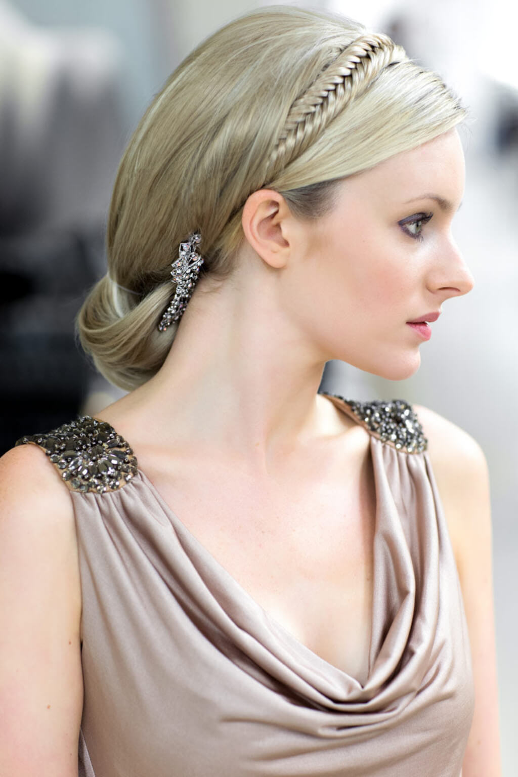 Woman with elegant hair and jewelery wearing a beige dress.  Fishtail plait hairband (braid) blonde 24H613