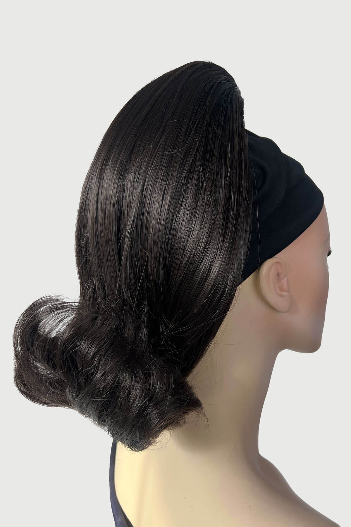 Mannequin head with a black hair bun and headband on a white background. Ponytail hairpiece, shoulder length with flick/flip, retro 1960s style: Ariana dark brown 4