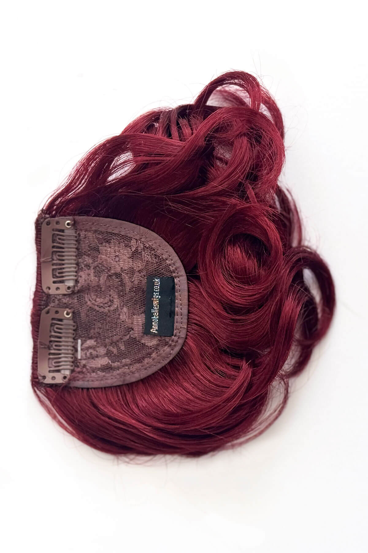 Red hair extension with a clip on a white background. Curly 1940s style clip-in fringe hairpiece/clip-in bangs: Bunny cherry red 39