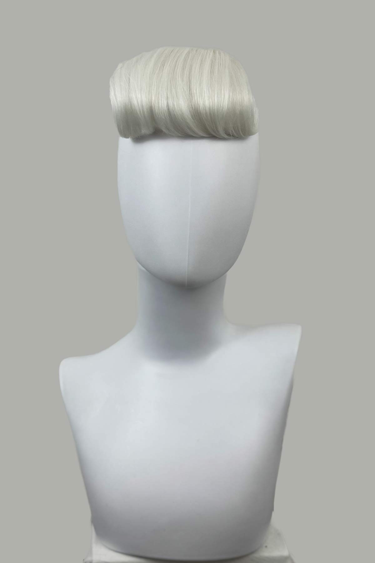 Mannequin head with a gray wig on a gray background. Victory roll fringe/bangs hairpiece, 1950s vintage style: Rosa platinum 1001