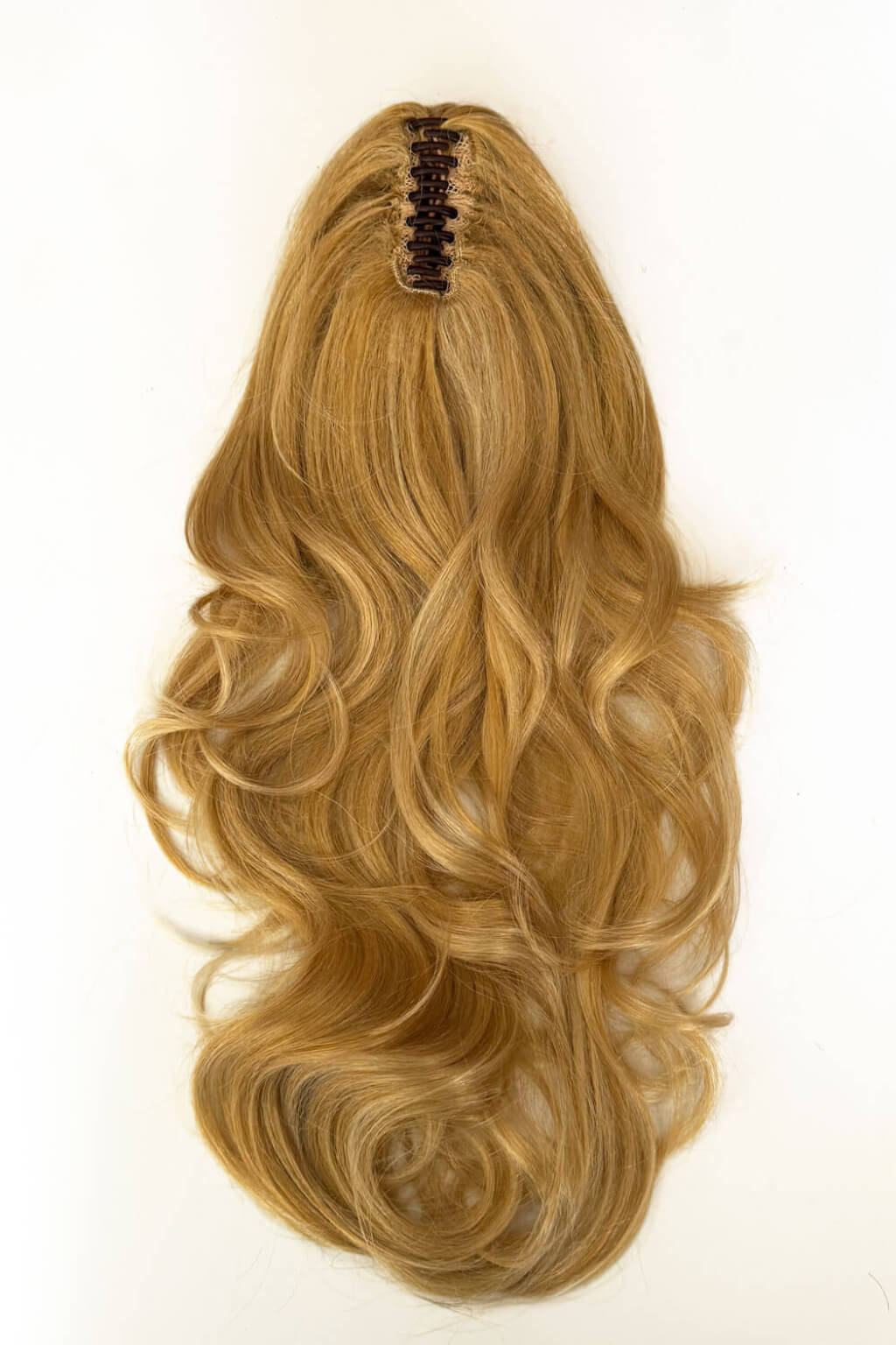 Blonde hair extension with wavy style on a white background. Clip-in ponytail hairpiece extension: Olivia golden blonde 24BH613
