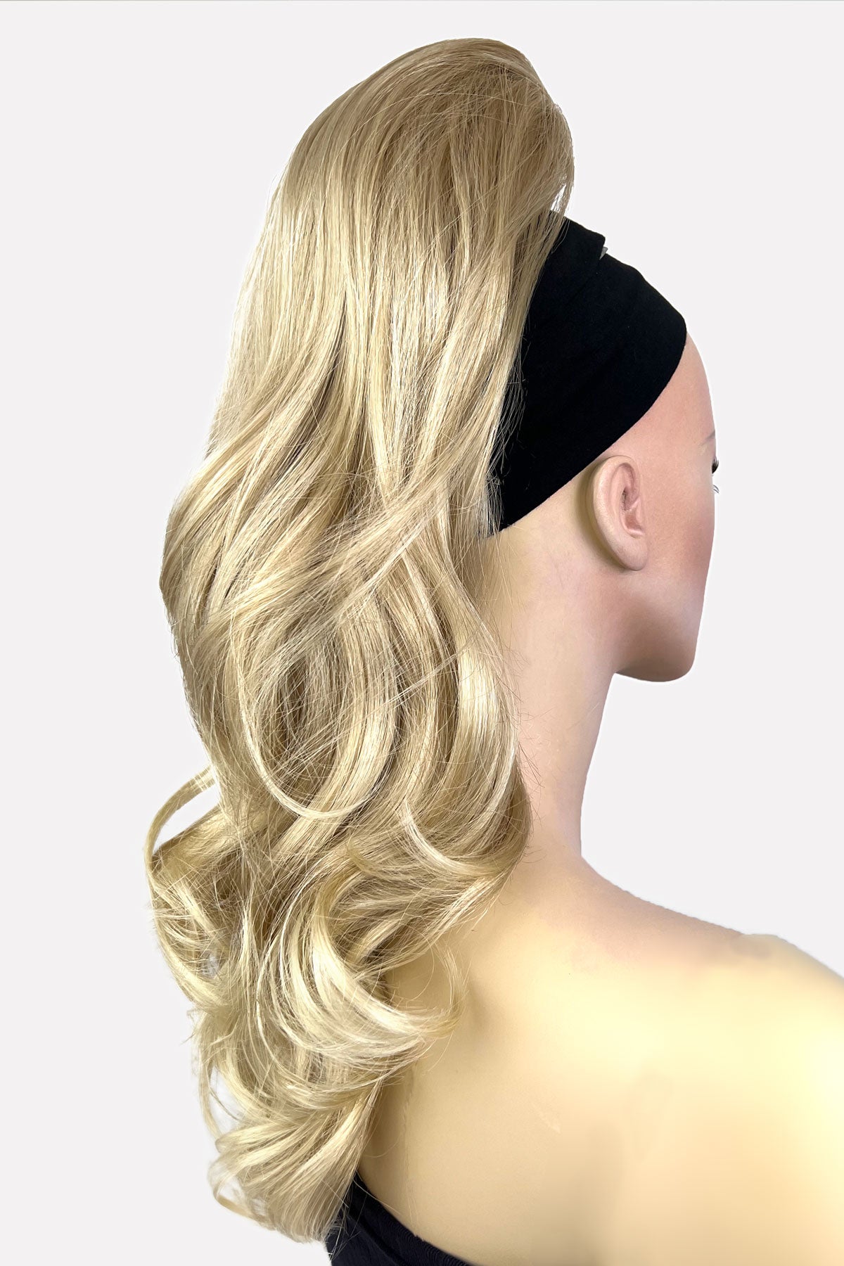 Mannequin head with long blonde hair and a black headband on a white background. Wavy, long ponytail hairpiece extension: Casey blonde 613T24