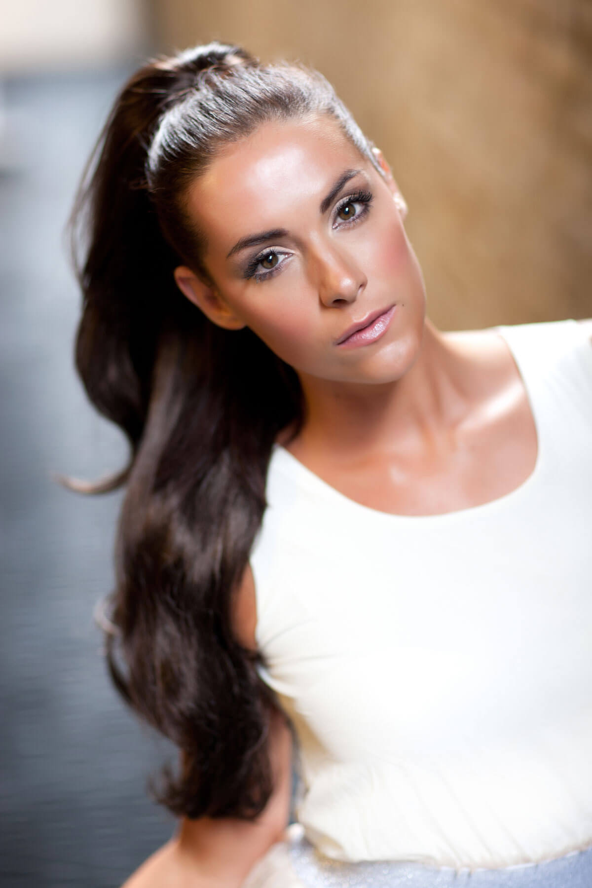 Woman with long dark hair styled in a half-up, half-down style against a blurred background. Clip-in ponytail hair piece extension, flexihair: Poppy light chocolate brown 12