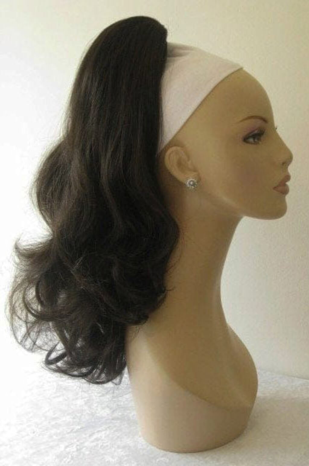 Mannequin head with a black ponytail wig on a white background. Ponytail hairpiece extension, layered with waves: Elsa dark brown 4