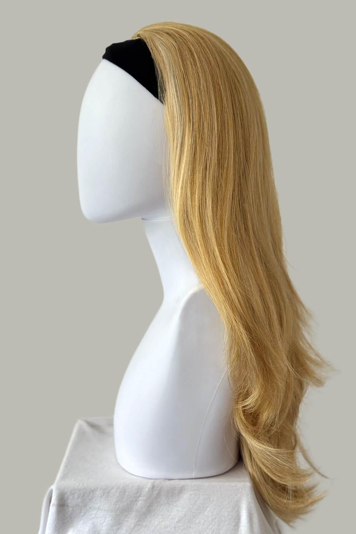 Blonde wig on a mannequin head against a plain background. Straight blonde half wig hairpiece (3/4 wig), layered: Autumn blonde 24BH613