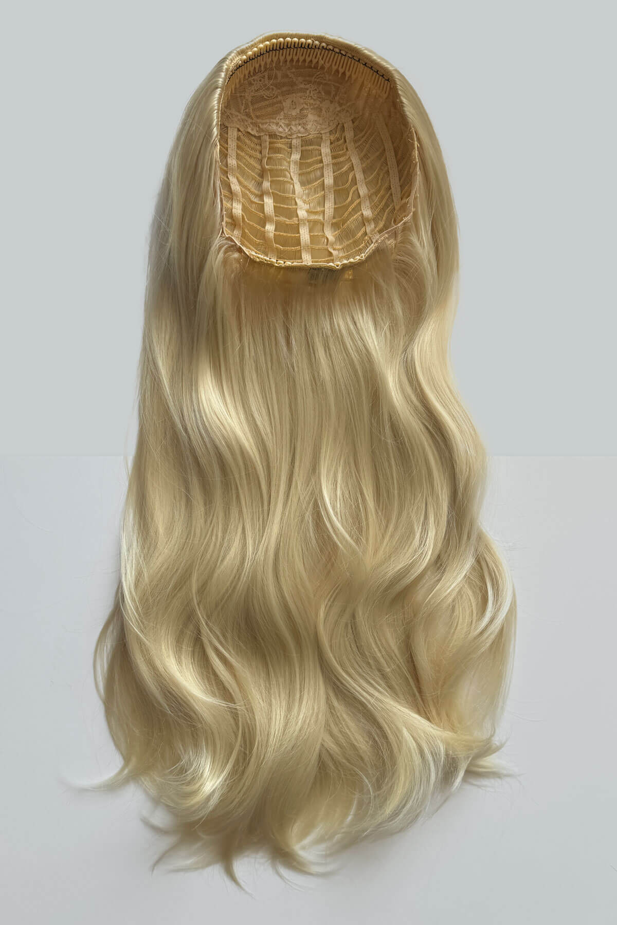 Blonde hair extension on a white background. Kate - Heat Styleable Extra Long, Gentle Wave Half Wig  blonde 613