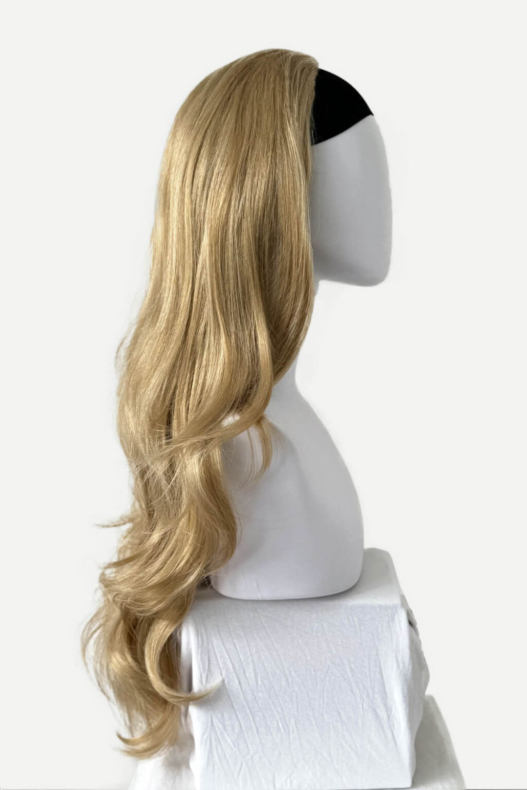 A long, wavy blonde wig with a black headband, displayed on a white mannequin head against a plain white background. Blonde half wig hairpiece (3/4 wig), loose curls: Suki blonde 24H613