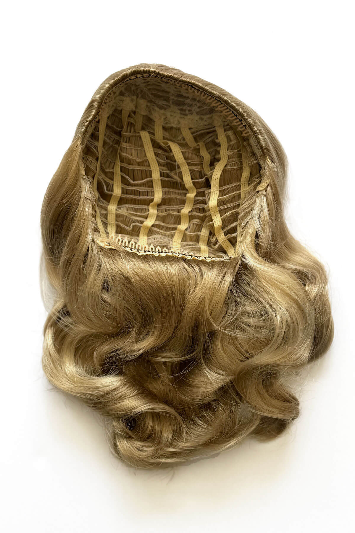 Blonde hairpiece on a white background.  1950s style shoulder length half wig hairpiece with beautiful vintage waves: Onyx blonde 24H613 