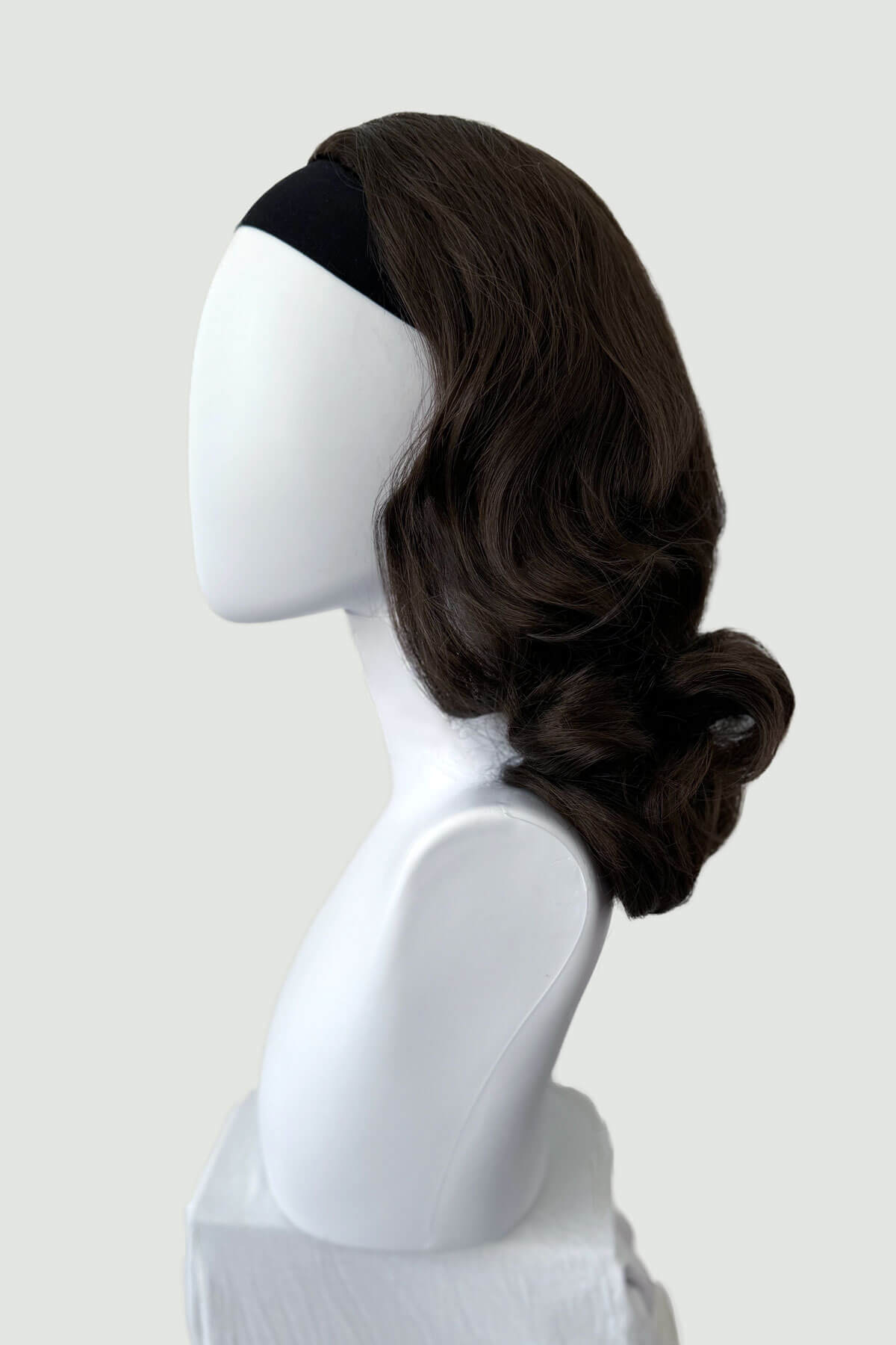 Mannequin head with long brown wig on a white background shown from the side. 1950s style shoulder length half wig hairpiece with beautiful vintage waves: Onyx chestnut brown 8 
