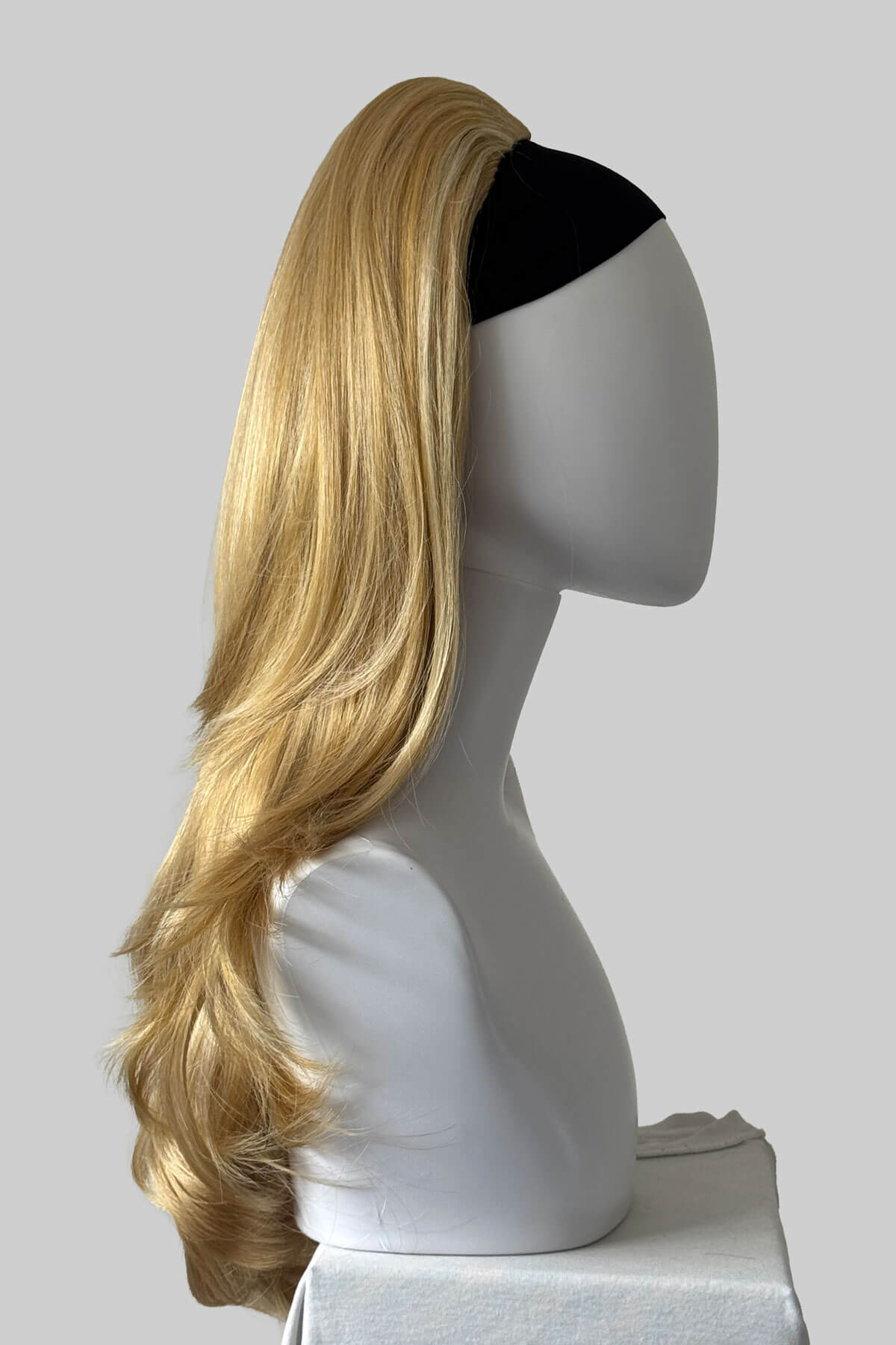 A long wavy blonde half wig, displayed on a mannequin against a light grey background. Claudia - Volume Boosting Long Gentle Bouncy Layered Half wig honey blonde 24BH613
