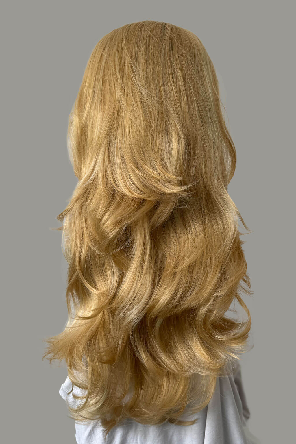 Blonde wig with wavy hair on a gray background - High crown long, layered half wig and volume ring: Helena golden blonde 24BH613