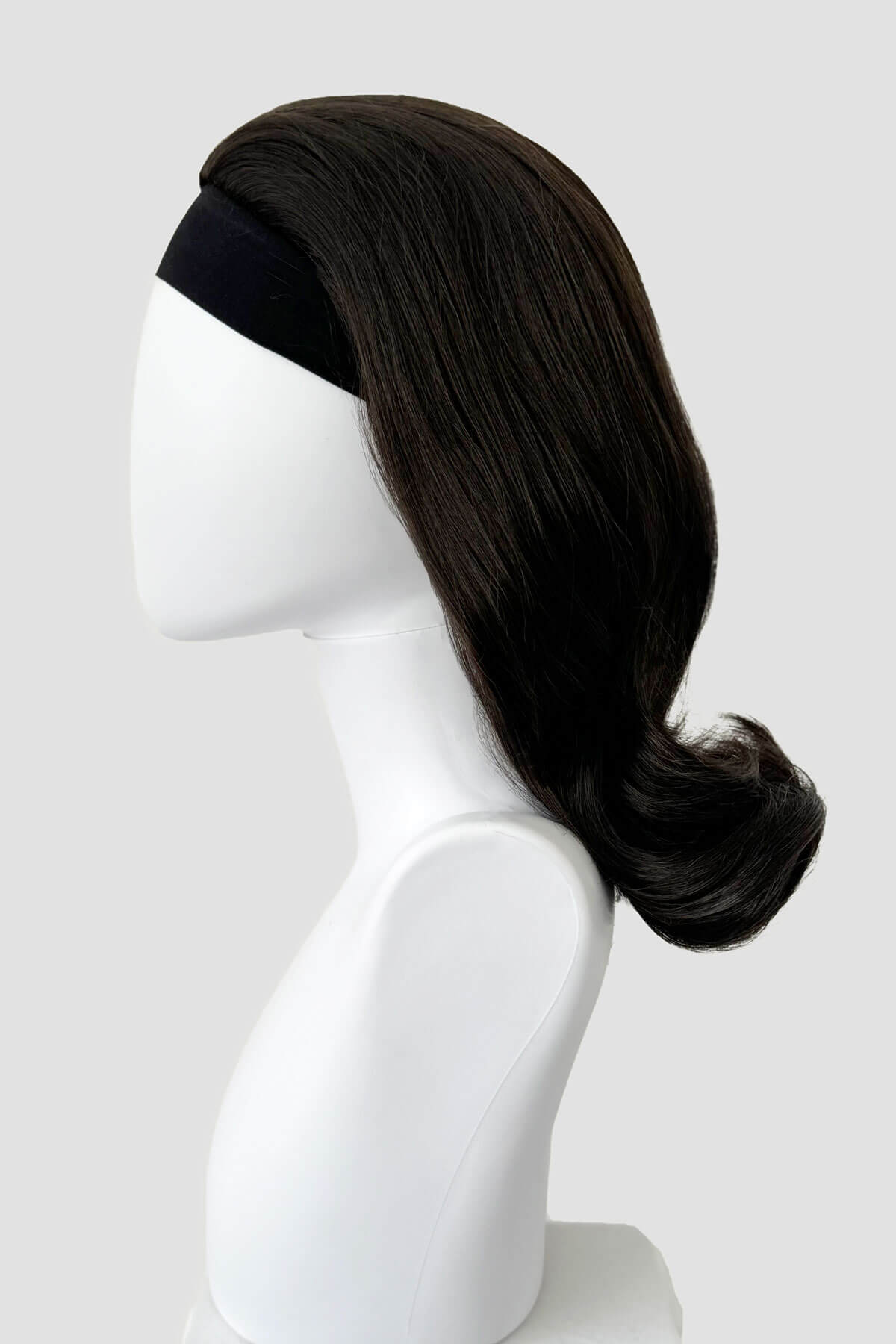 Dark brown wig on a white mannequin head against a light gray background. 1960s half wig hairpiece, flicked, hair flip: Philippa dark brown 4