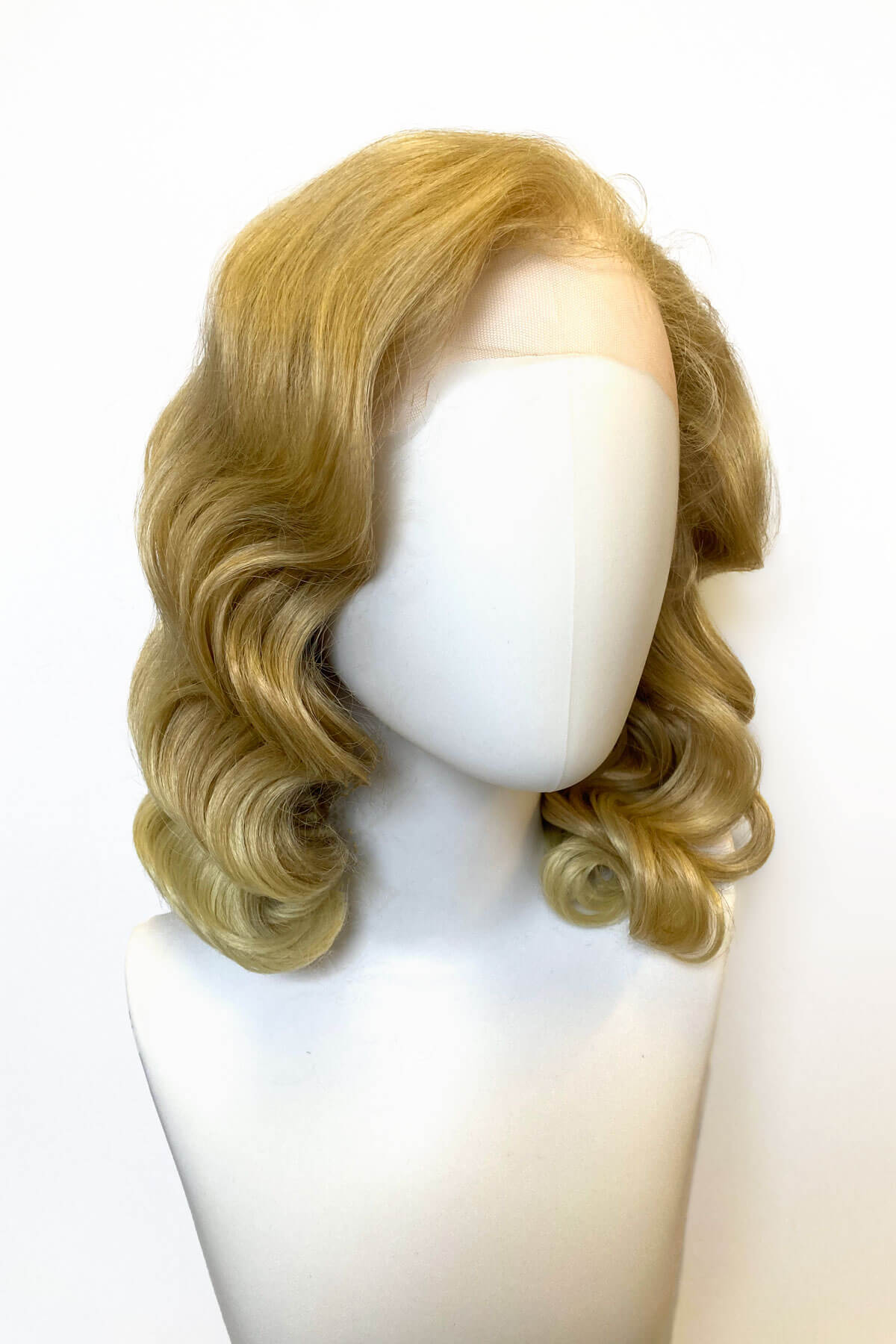 Blonde wig on a mannequin head against a white background. Blonde pinup wig, lace front: Irina