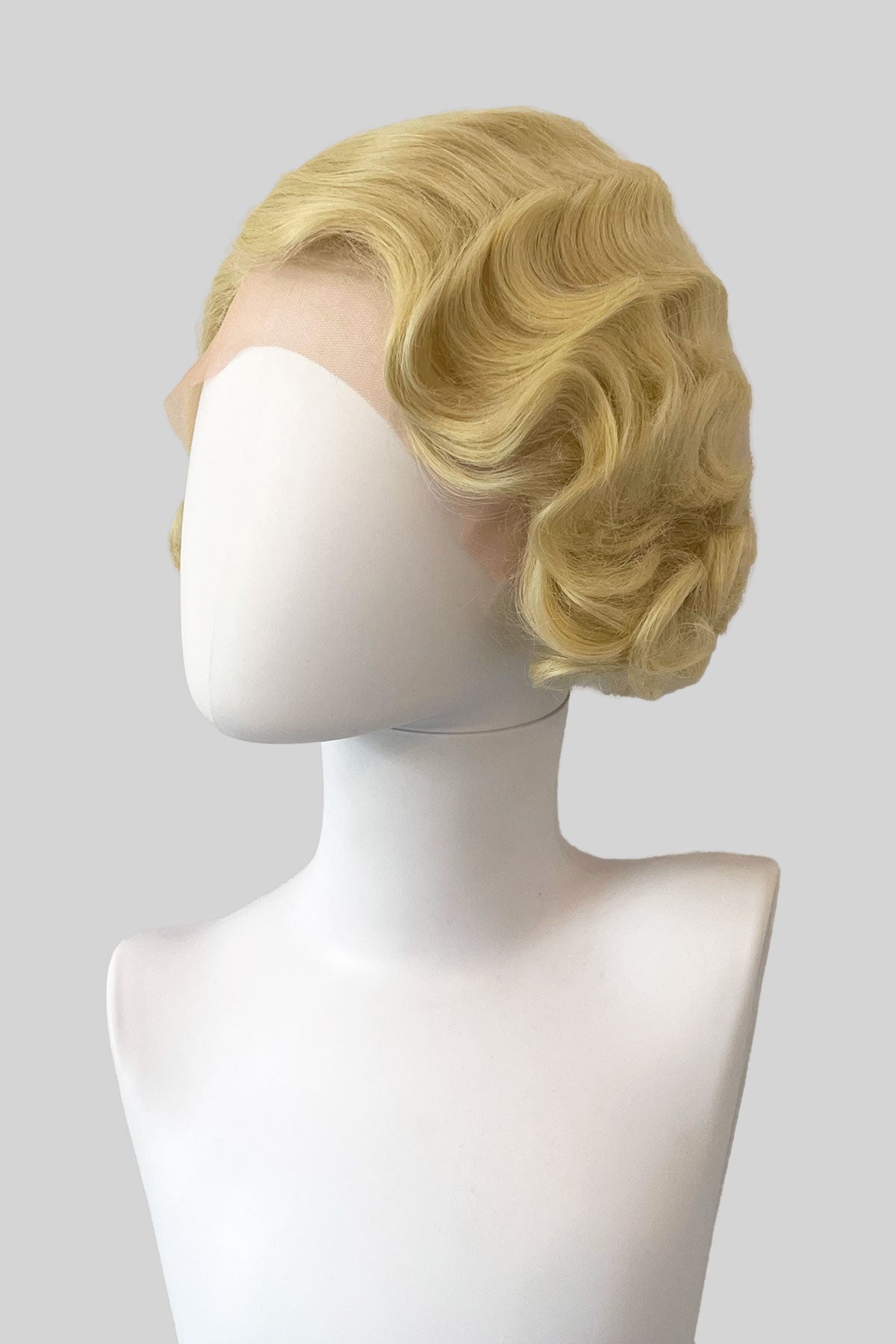 Blonde wig on a mannequin head with a white background.  Blonde pinup wig, lace front, vintage style: Odette blonde 613