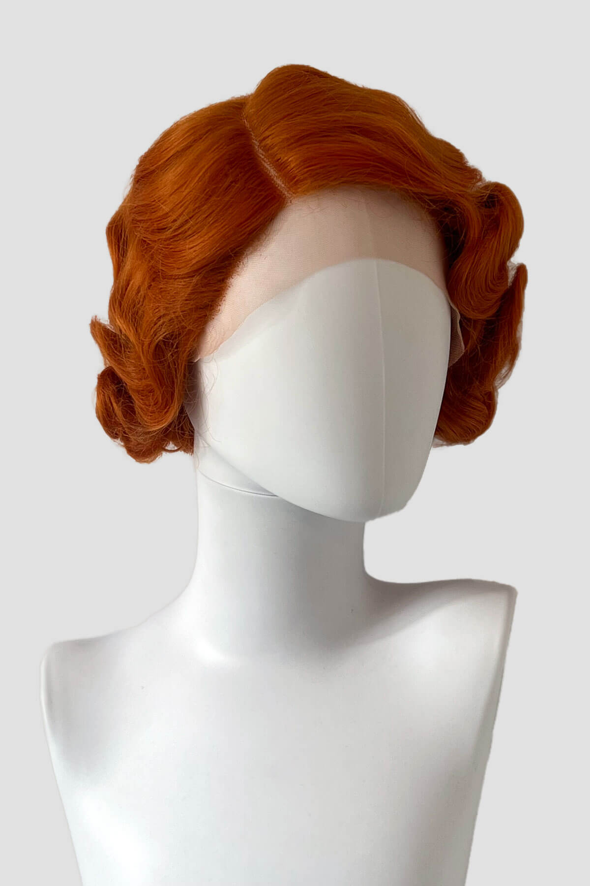 Red wig on a mannequin head against a white background. Ginger pinup wig, lace front, vintage style: Flo