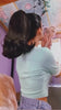 Woman with  dark brown flicked ponytail looking in the mirror. Ponytail hairpiece, shoulder length with flick/flip, retro 1960s style: Ariana dark brown 4