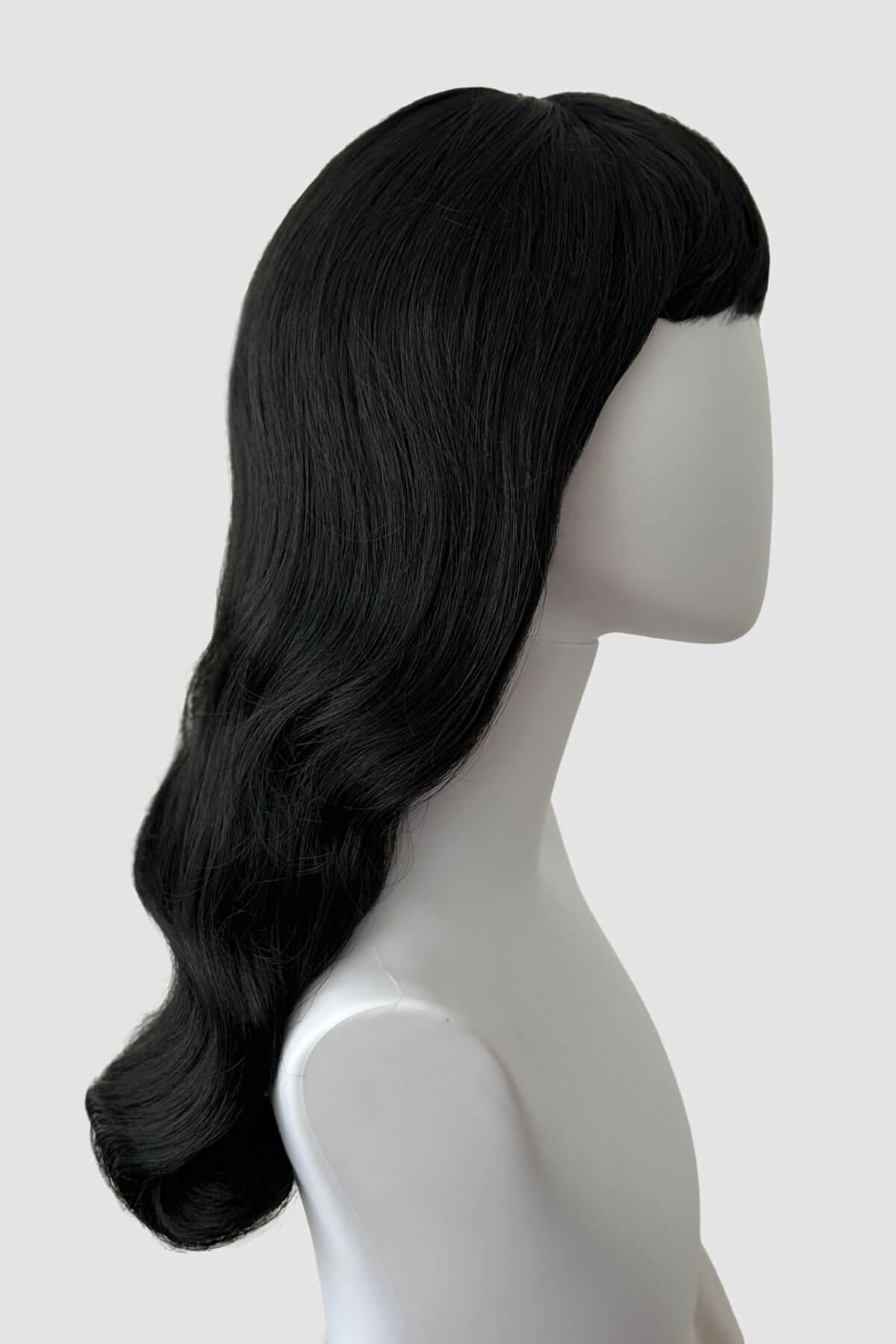 Black wig on a mannequin head against a white background. Black pinup style wig, old Hollywood waves with short fringe: Milena