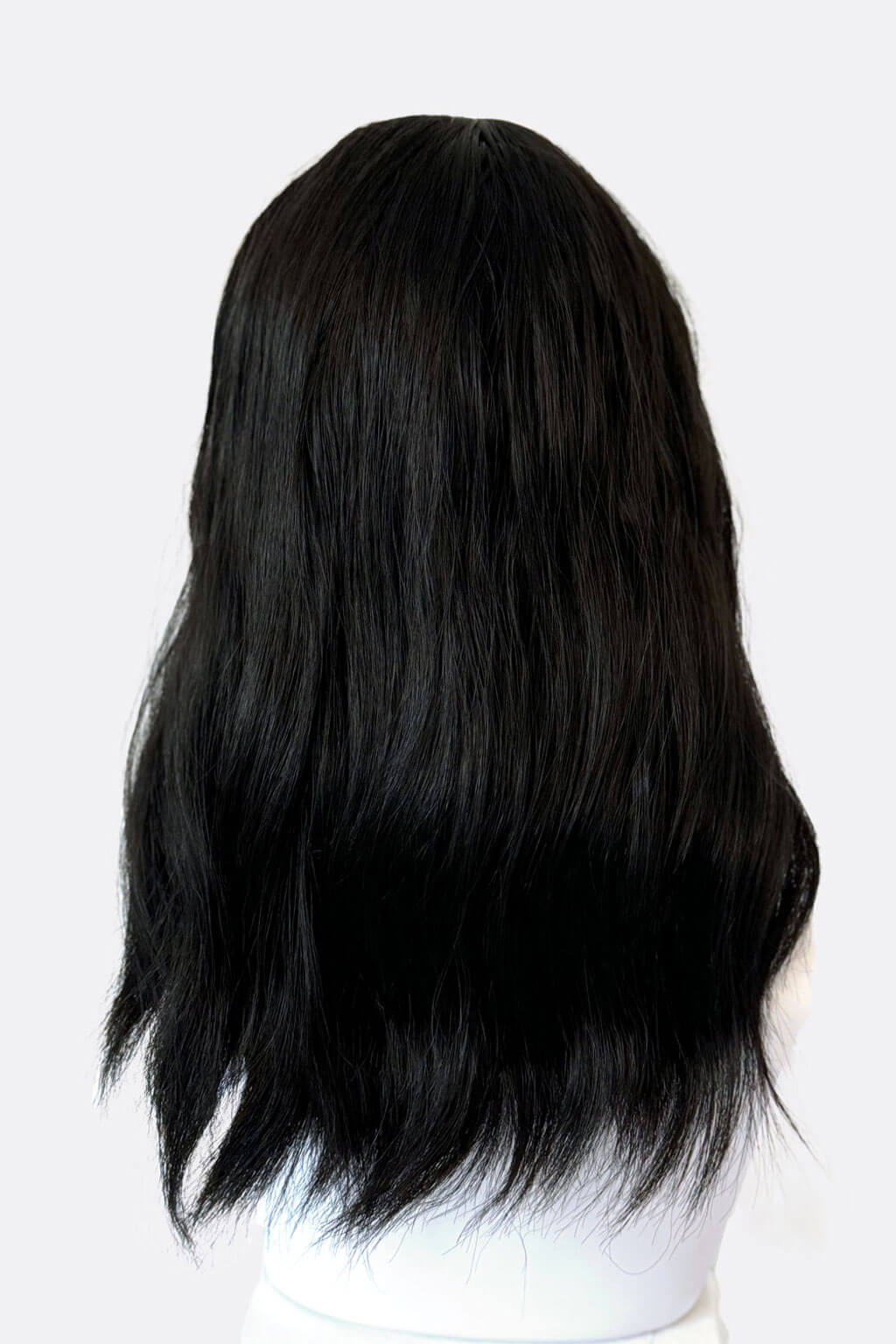 Black wig on a mannequin head against a white background. Black long wavy bob wig (lob): Sigrid