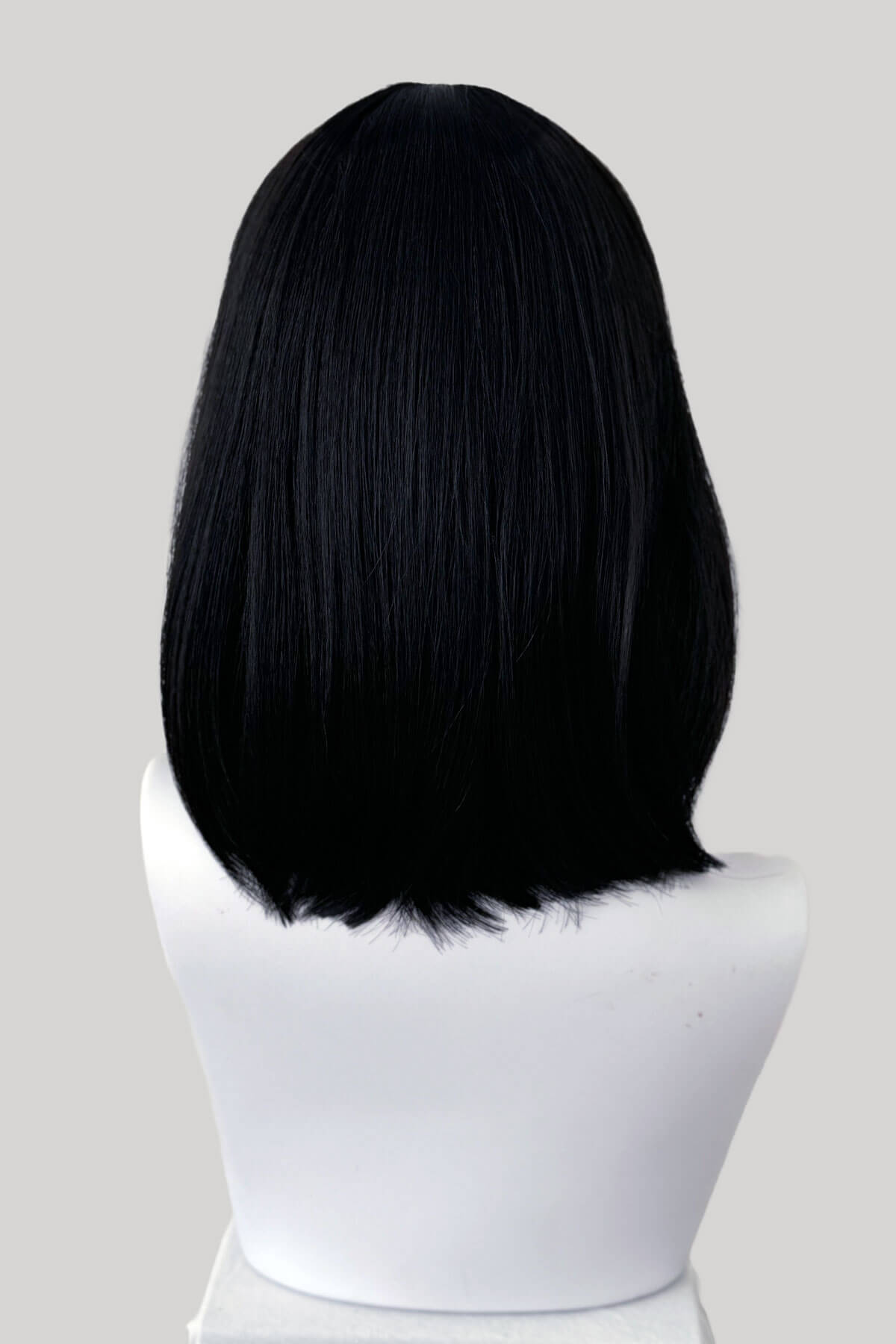 Black wig on a mannequin head against a gray background. Black long bob wig, shoulder length: Evie