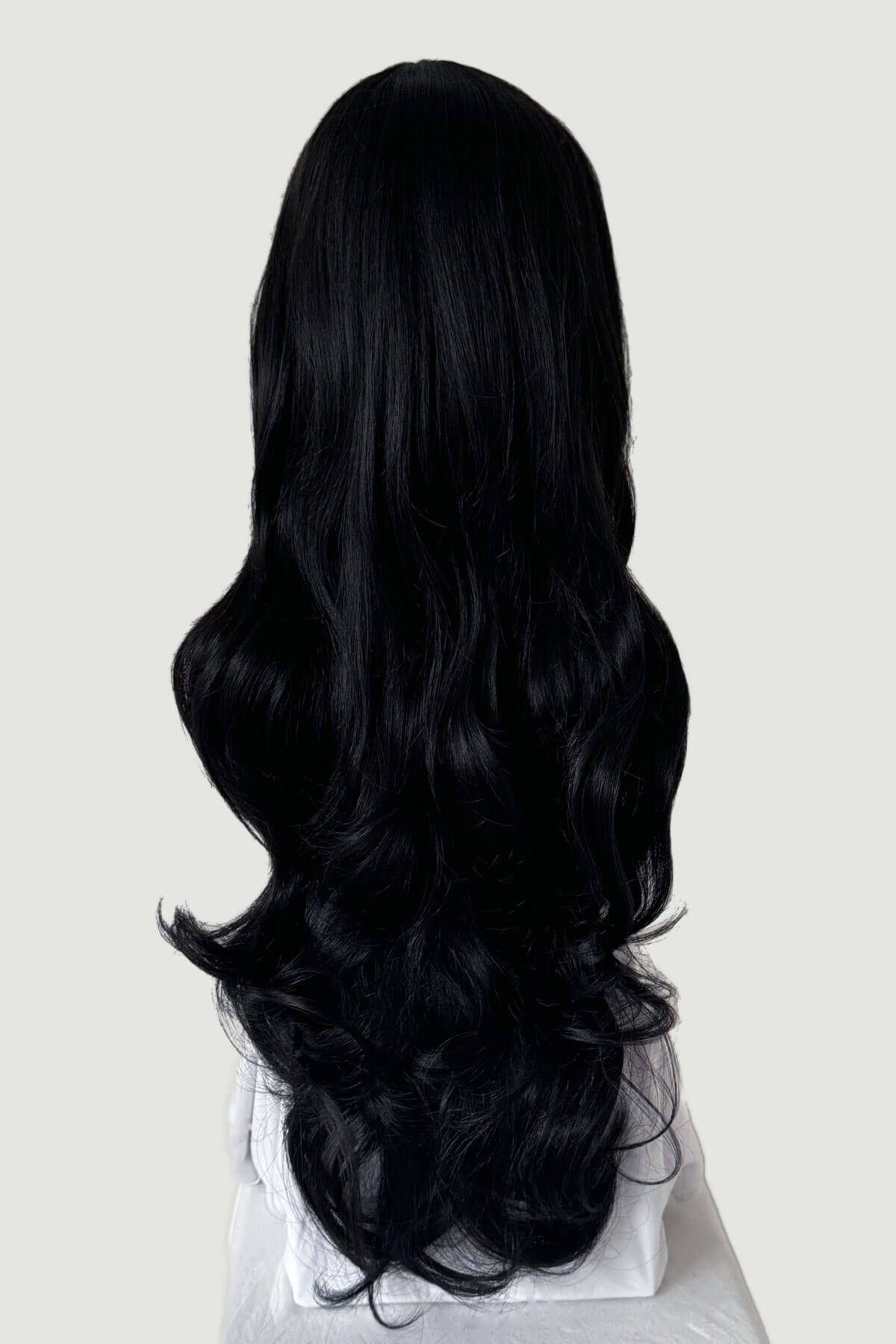 Black wig on a white background. Long wavy black wig with vintage-style, rockabilly, straight fringe: Eloise