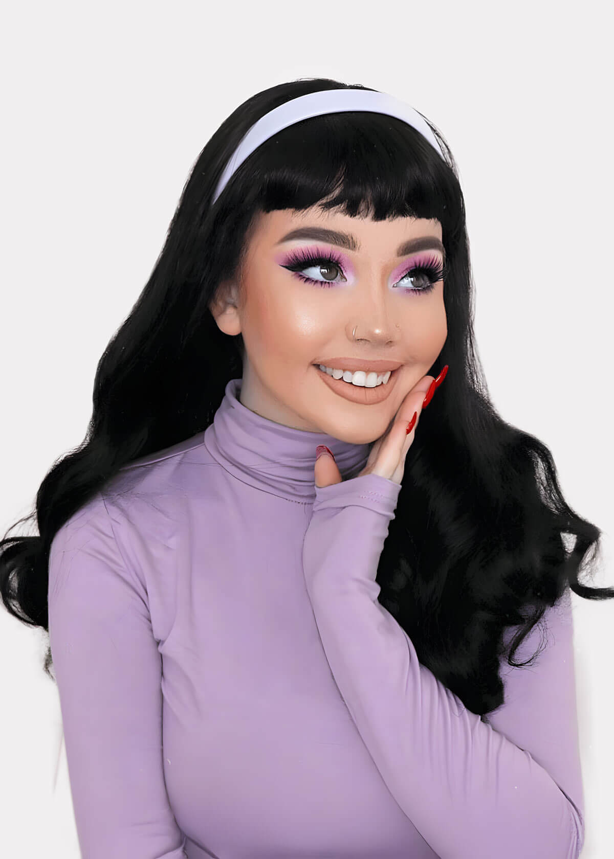 Woman wearing a light purple turtleneck and black hair with a white headband on a white background. Long wavy black wig with vintage-style, rockabilly, straight fringe: Eloise