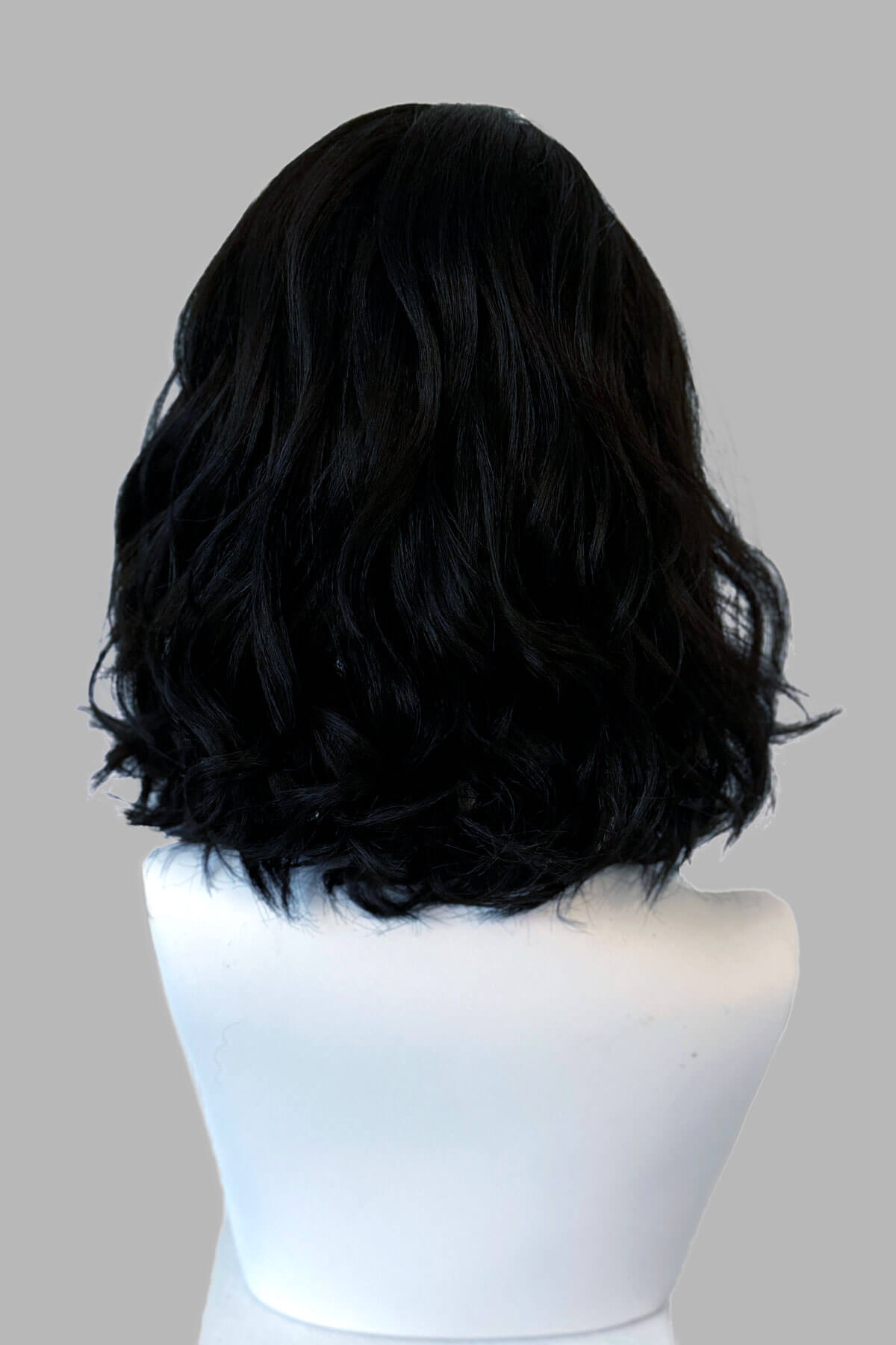 Black wig on a mannequin head against a gray background. Black long wavy bob (lob) wig with swept fringe: Eleena