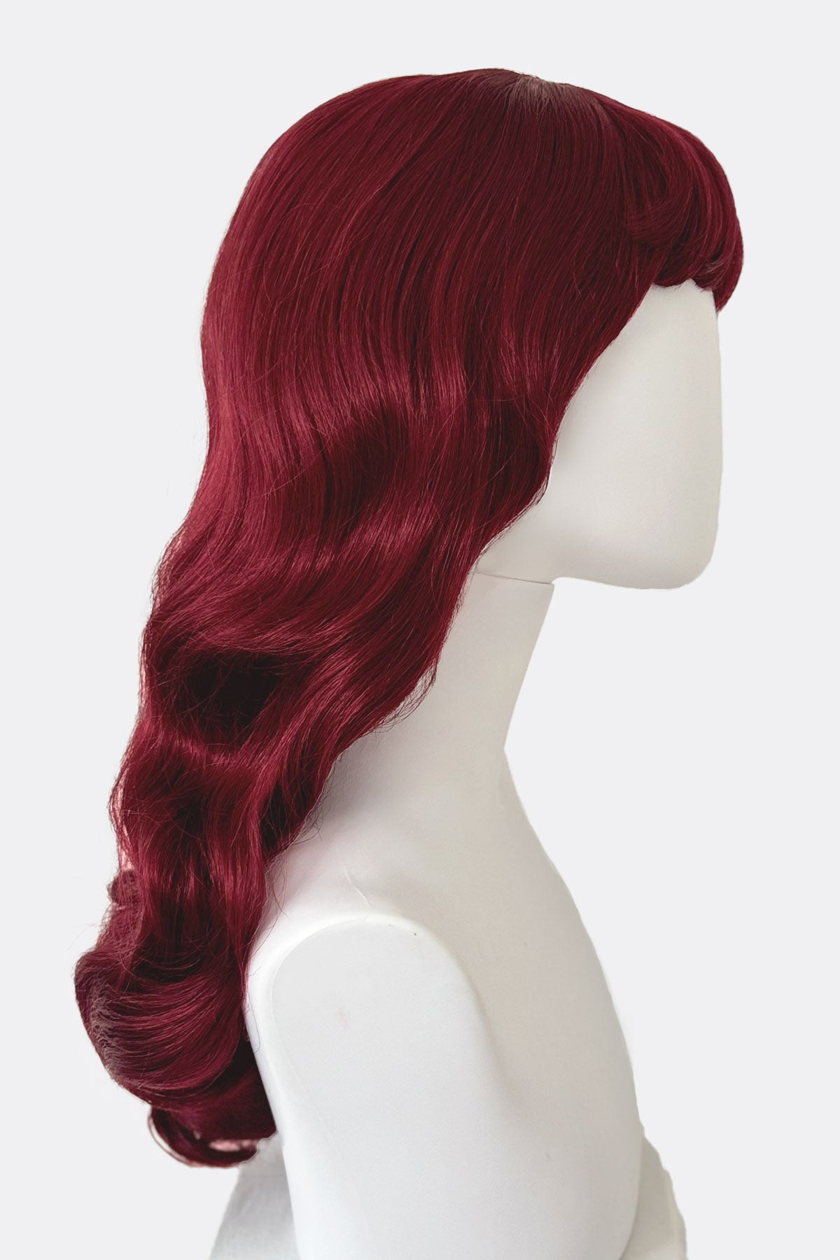 Red wig on a mannequin head against a white background.  Long cherry red pin-up wig, gently wavy with short fringe: Maeve