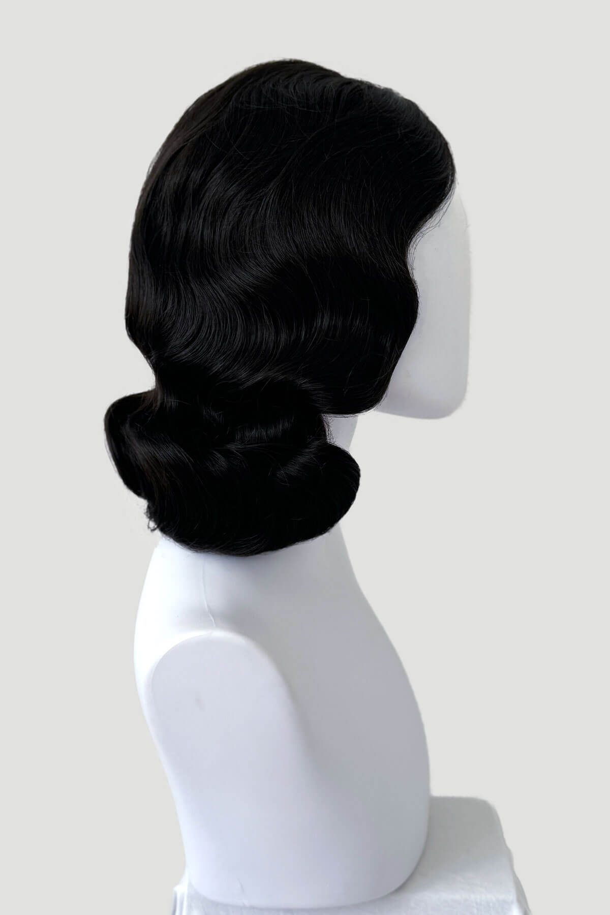 Black wig on a mannequin head against a white background. Brown 1940s pinup style wig, with finger waves: Honey dark brown 4