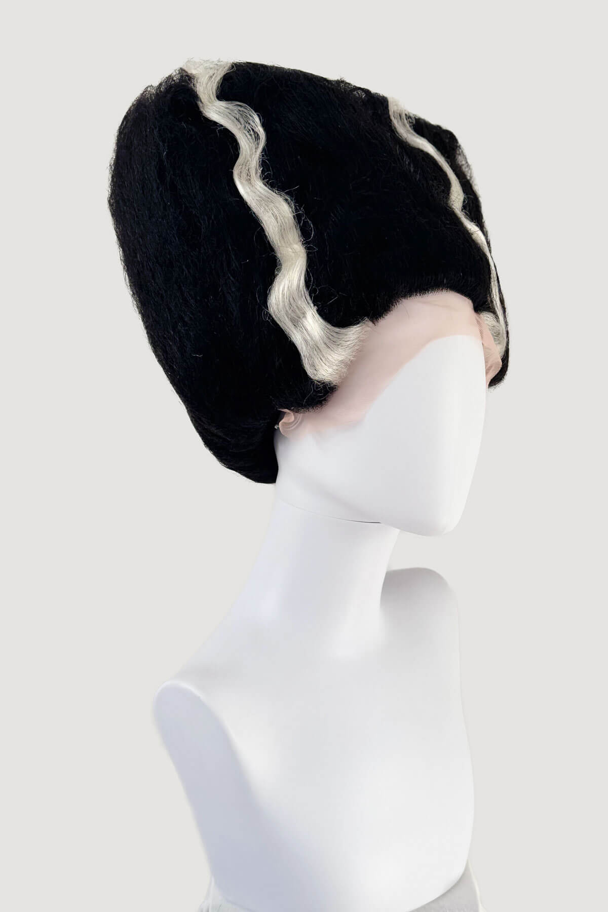 Black wig with white fringe on a mannequin head against a white background. Black wig with white fringe on a mannequin head against a white background. Bride of Frankenstein lacefront wig, black with platinum streaks: Eva