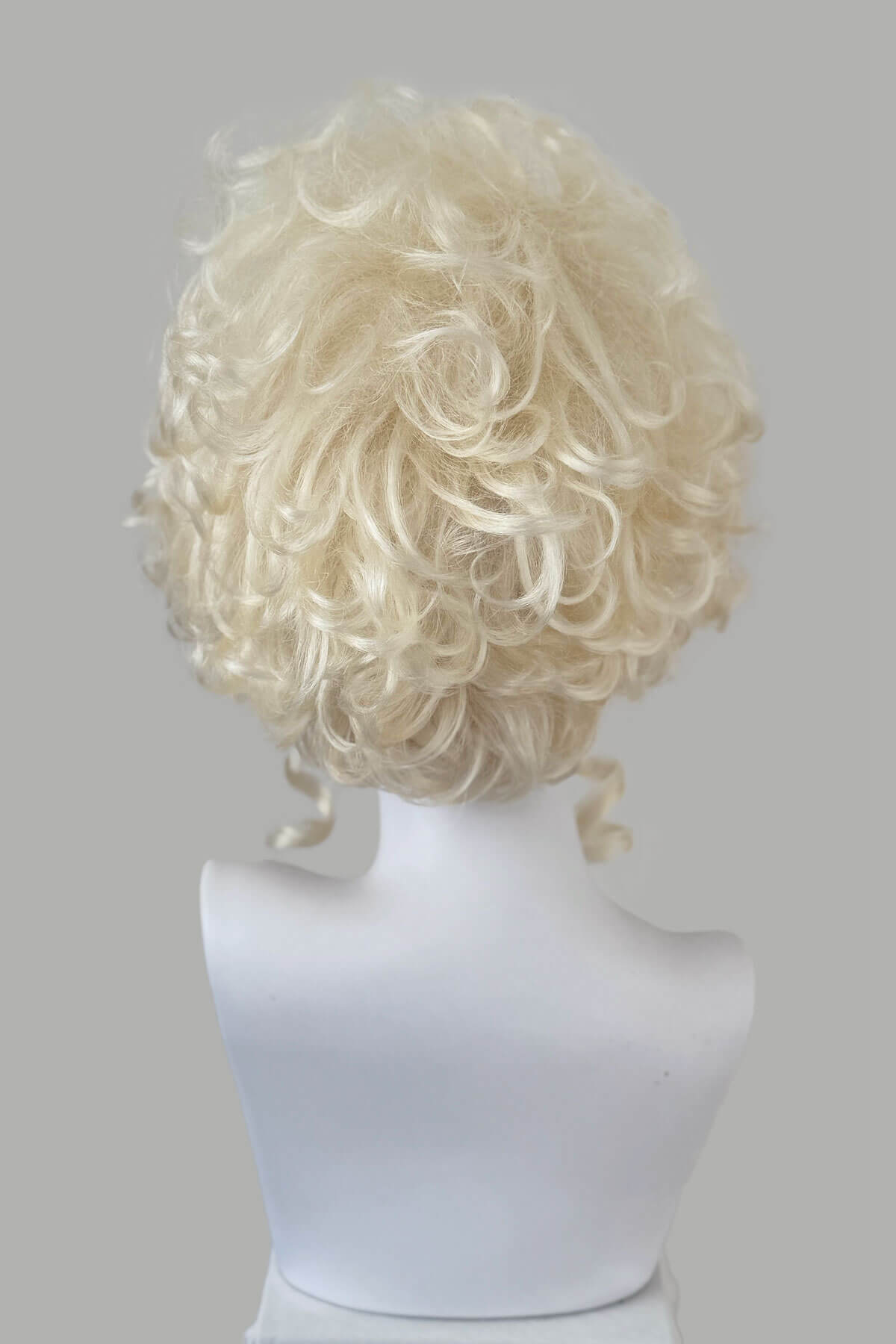 Blonde wig on a mannequin head against a gray background. Platinum blonde Marie Antoinette style wig: Marie platinum blonde 1001