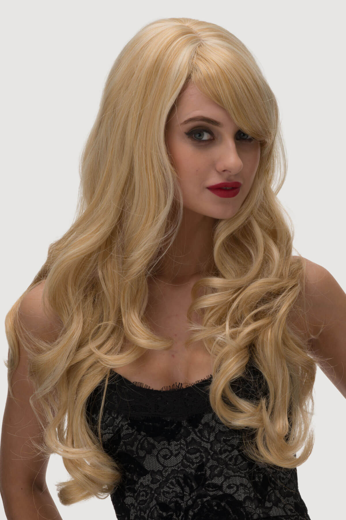 Woman with long blonde wig and red lipstick against a white background. Long golden blonde wig, with extra long waves: Cassidy