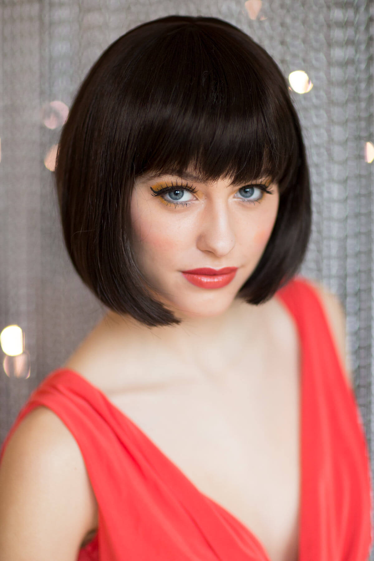 Woman with a bob haircut wearing a red dress against a neutral background. Brown bob wig, chic and stylish: Honour dark brown 4