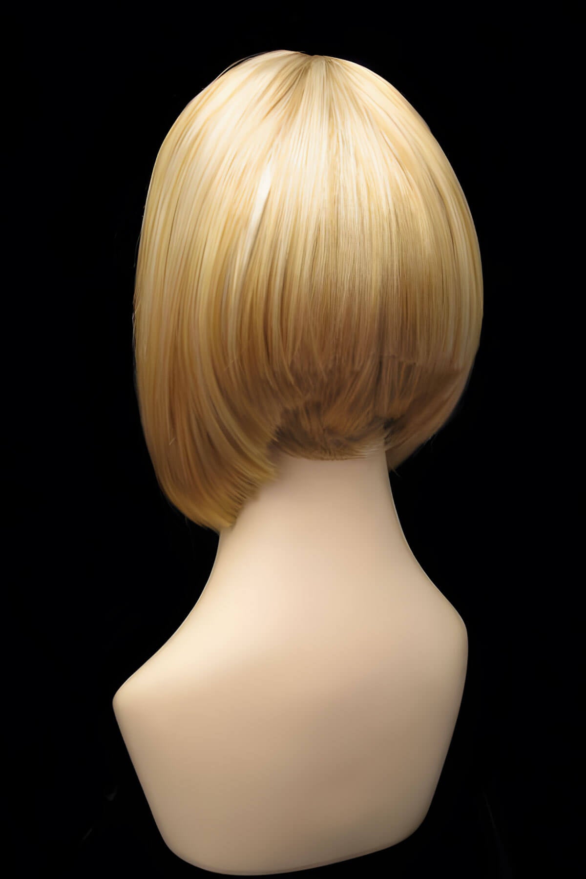 Blonde wig on a mannequin head against a black background.  Blonde inverted bob wig: Rhiannon honey blonde 24BH613
